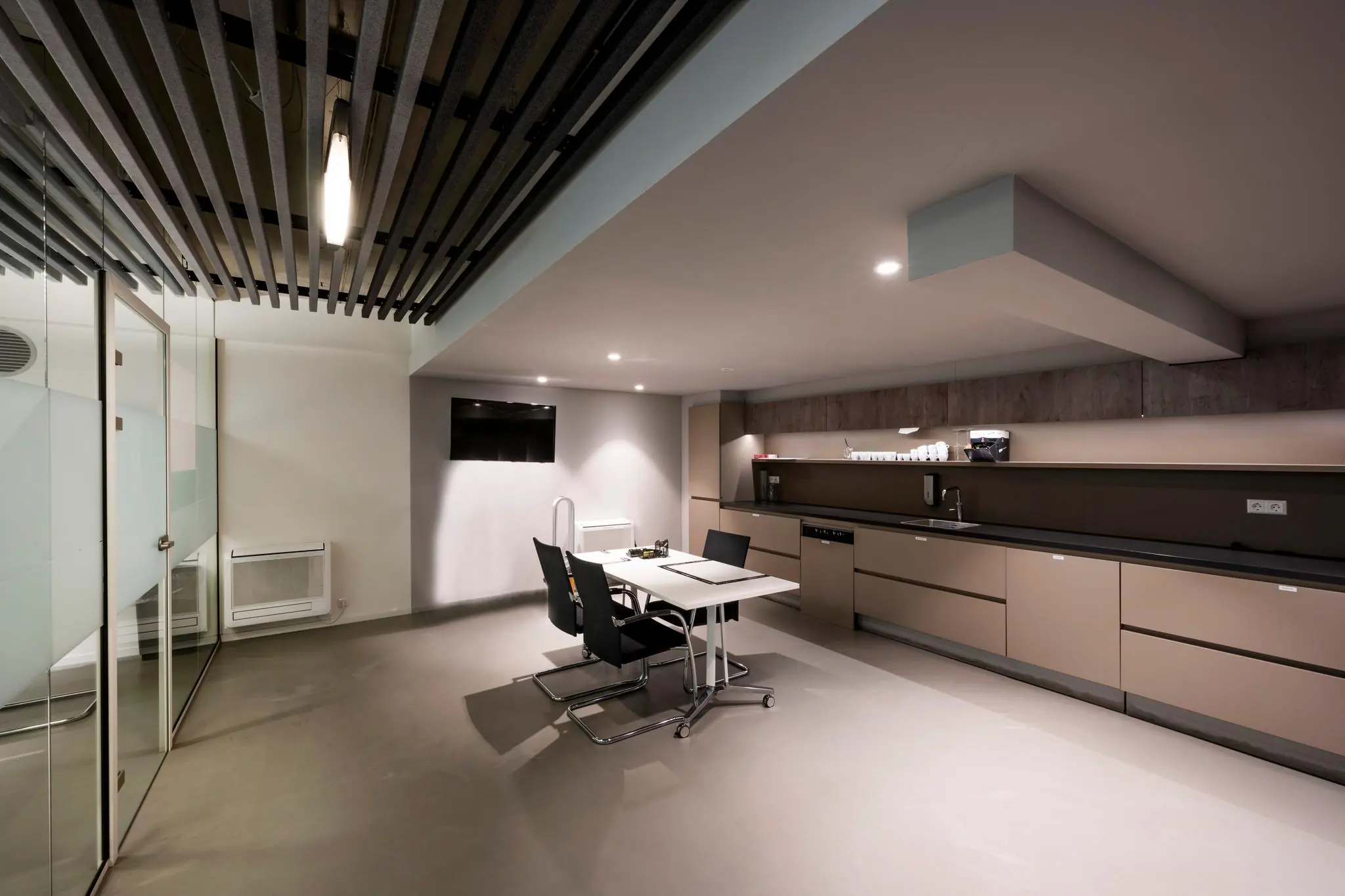 Moderne kantoorruimte aan de Fred. Roeskestraat met strakke keuken, vergadertafel en minimalistisch interieur.